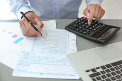 Photo of Tax accountant working with documents at table