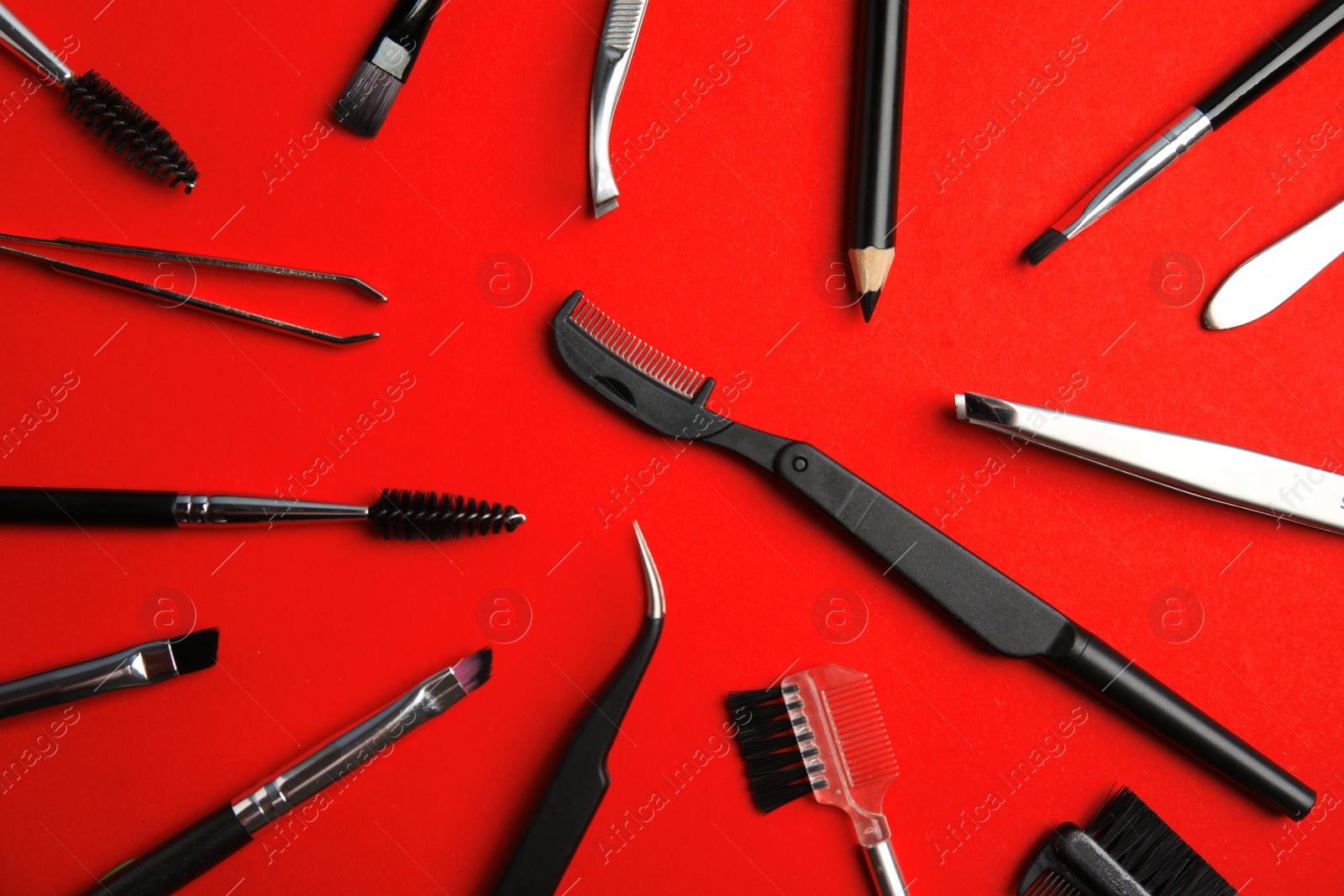 Photo of Set of professional eyebrow tools on red background, flat lay