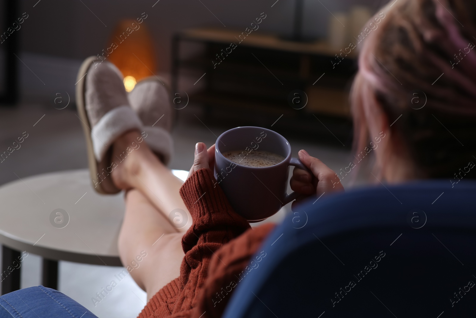 Photo of Woman with cup of aromatic coffee relaxing at home, closeup