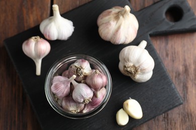 Many fresh garlic bulbs on wooden table, top view