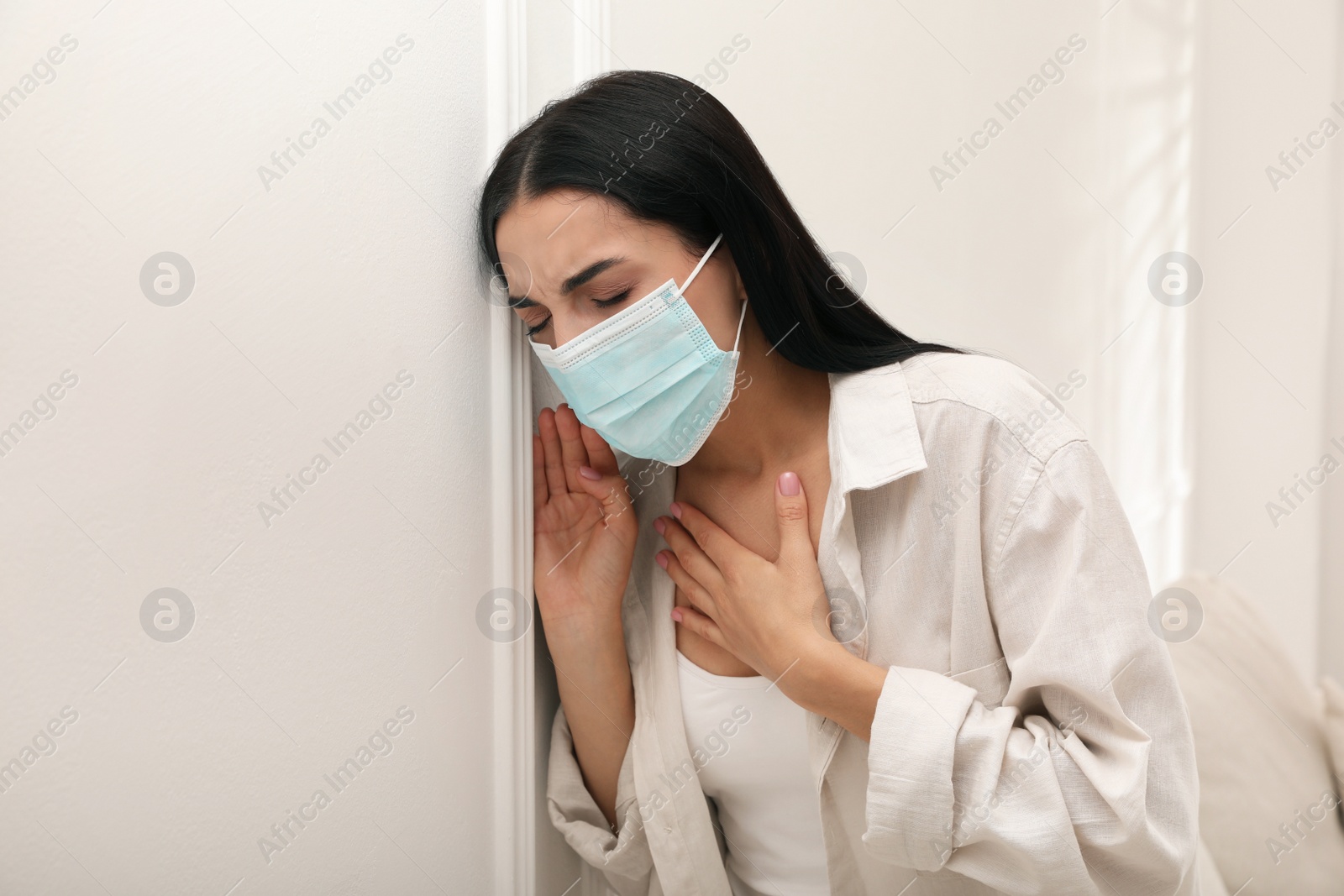 Photo of Young woman with protective mask suffering from breathing problem at home