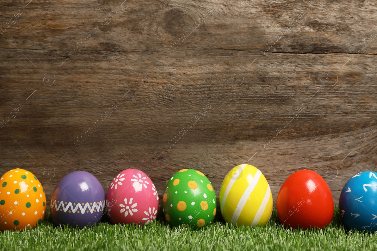 Photo of Decorated Easter eggs on green grass. Space for text