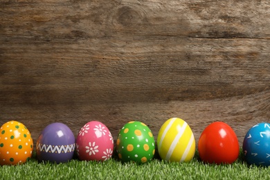 Photo of Decorated Easter eggs on green grass. Space for text