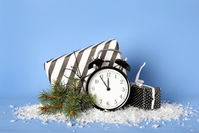 Photo of Vintage alarm clock with Christmas decor on light blue background. New Year countdown