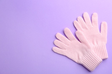 Photo of Pair of stylish woolen gloves on violet background, flat lay. Space for text