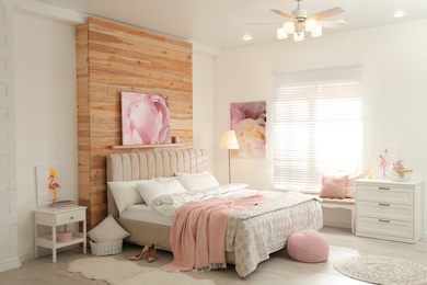 Photo of Stylish bedroom interior with modern ceiling fan and pictures