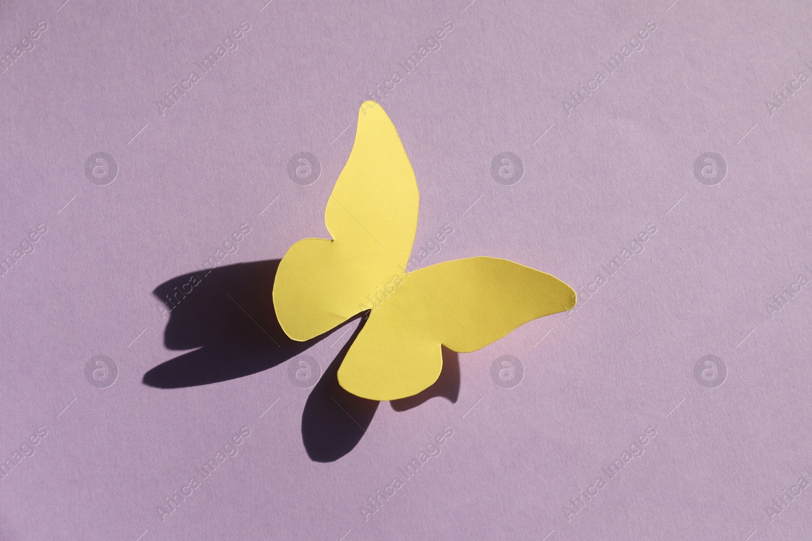 Photo of Yellow paper butterfly on violet background, top view