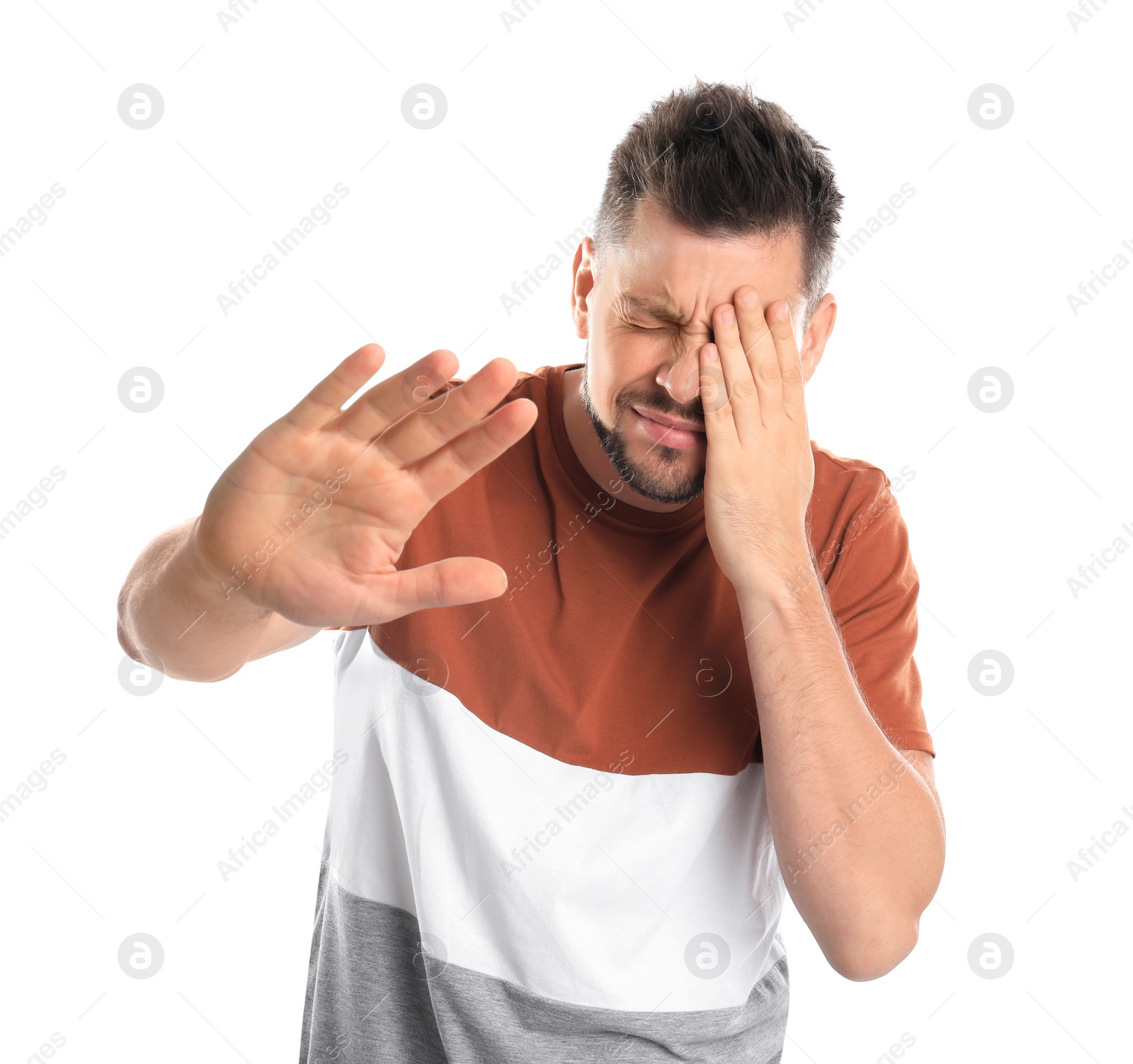 Photo of Man covering eye while being blinded on white background