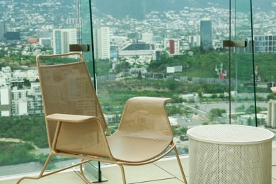 Photo of Coffee table and chair against picturesque landscape of city in cafe