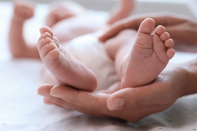 Mother and her newborn baby on bed, closeup