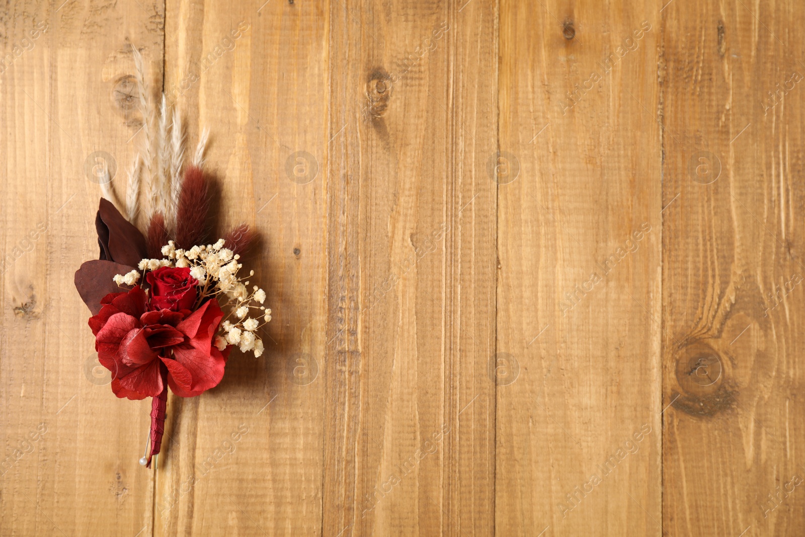 Photo of Beautiful boutonniere on wooden background, top view. Space for text