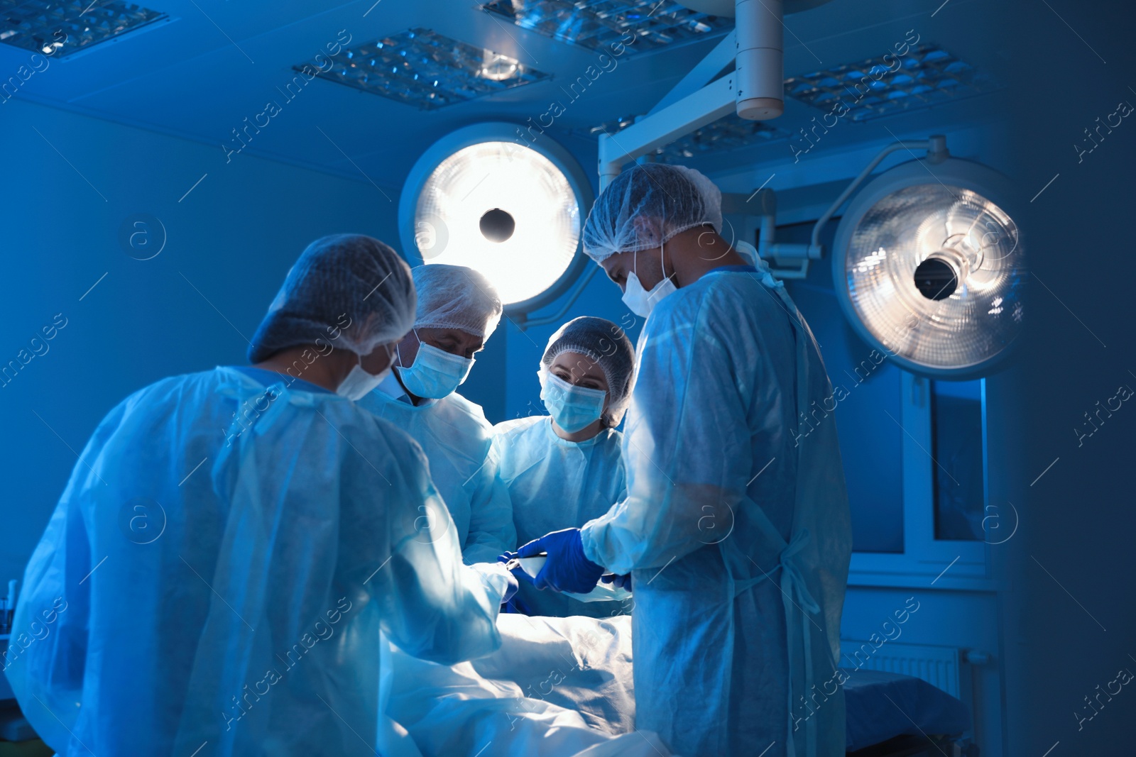 Photo of Team of professional doctors performing operation in surgery room