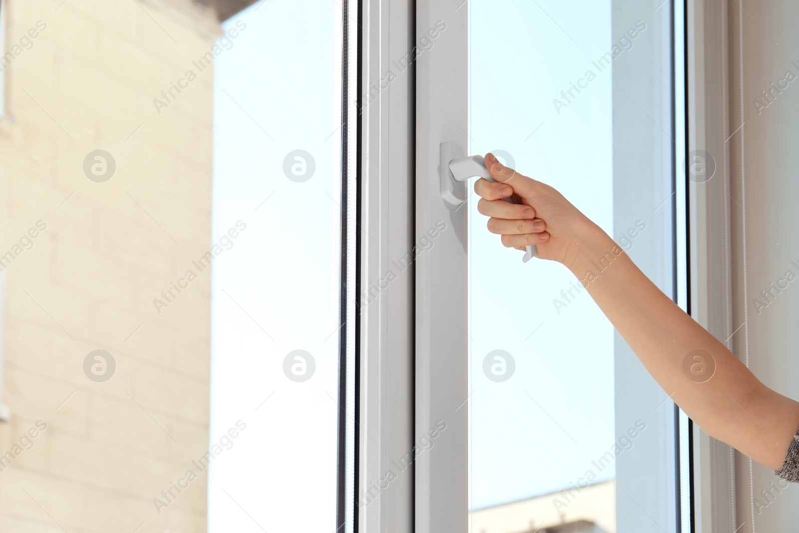 Photo of Woman opening new modern window, closeup view