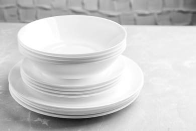 Photo of Stack of clean plates on table