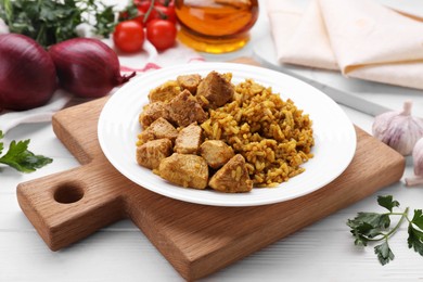 Photo of Delicious rice with chicken served on white wooden table