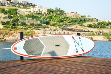 Photo of SUP board on wooden pier near sea