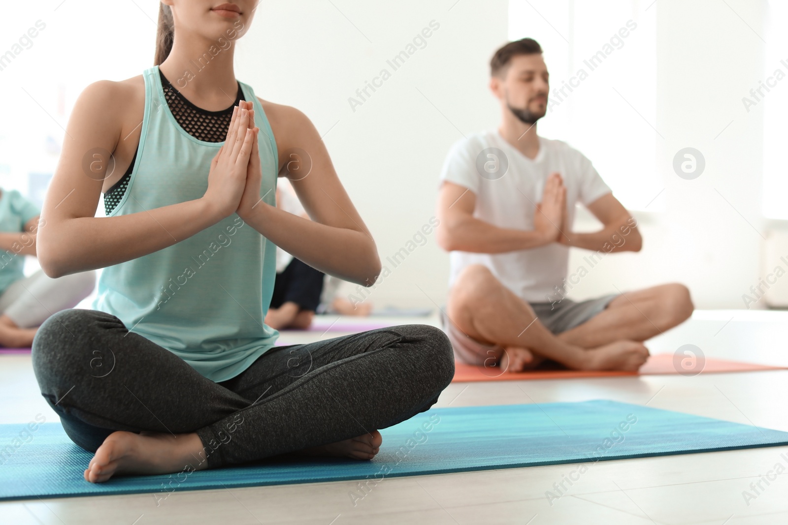 Photo of Group of people in sportswear practicing yoga indoors