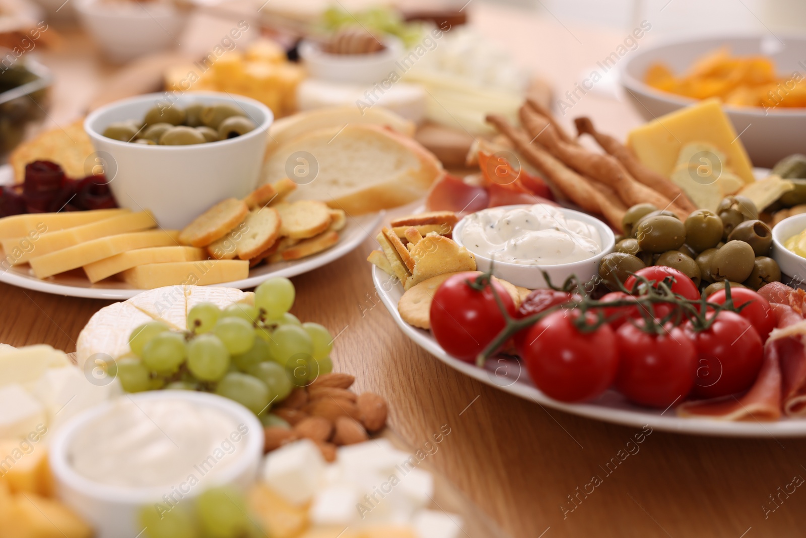 Photo of Assorted appetizers served on wooden table, closeup