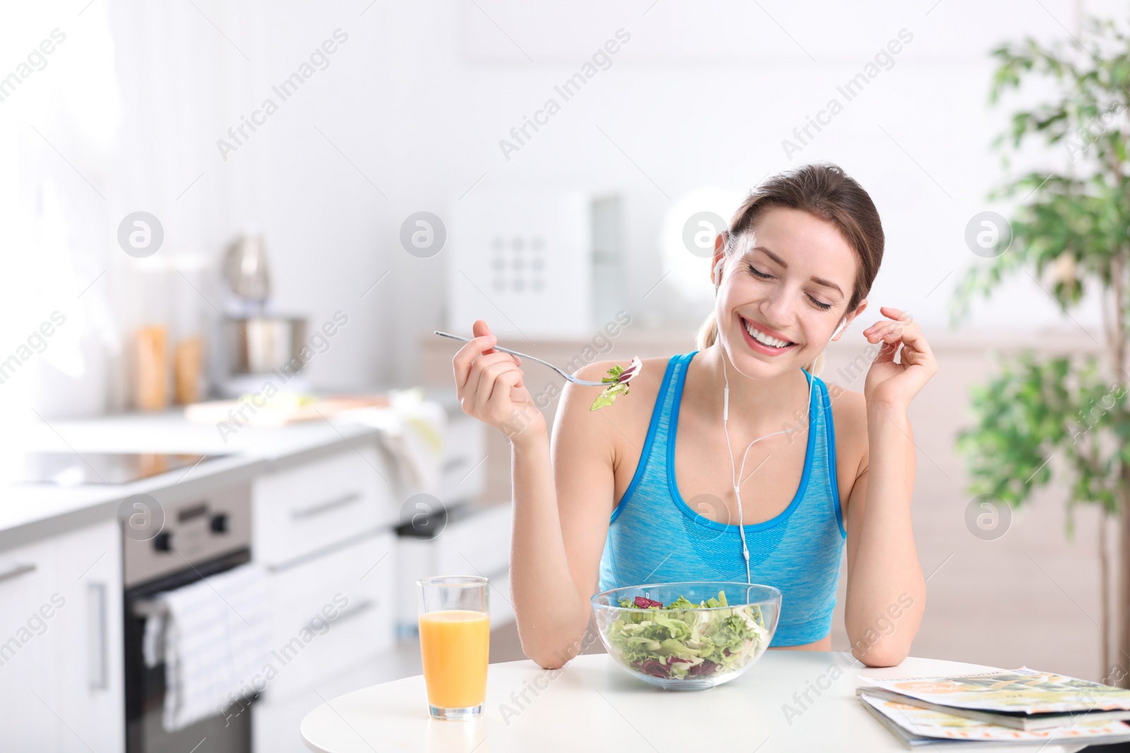 Photo of Young woman in fitness clothes having healthy breakfast at home. Space for text