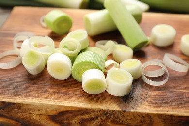 Fresh raw leek slices on wooden board, closeup