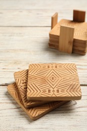 Stylish cup coasters on white wooden table