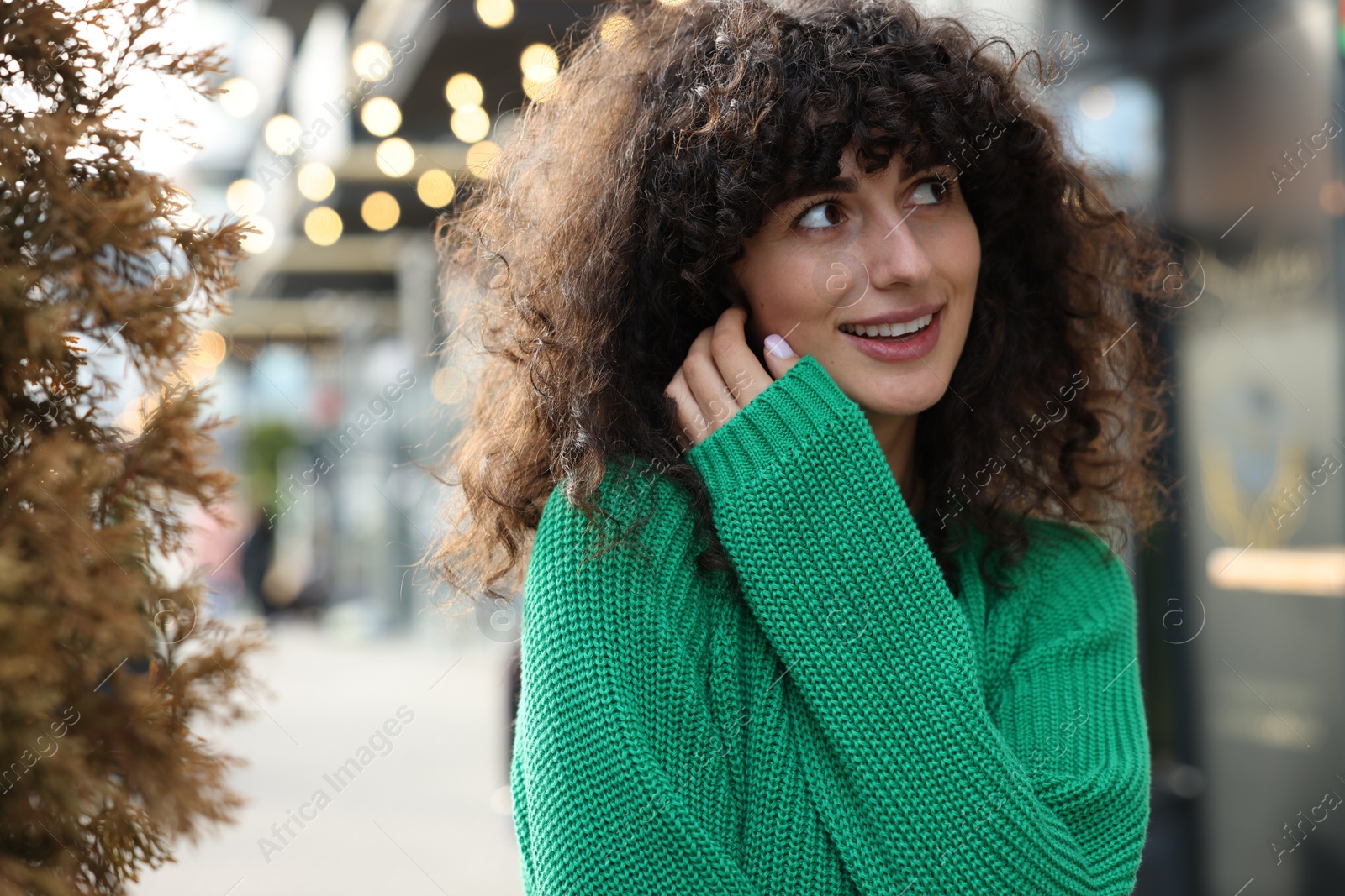 Photo of Happy young woman in stylish green sweater outdoors