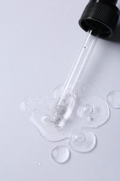 Photo of Pipette with cosmetic serum on white background, above view