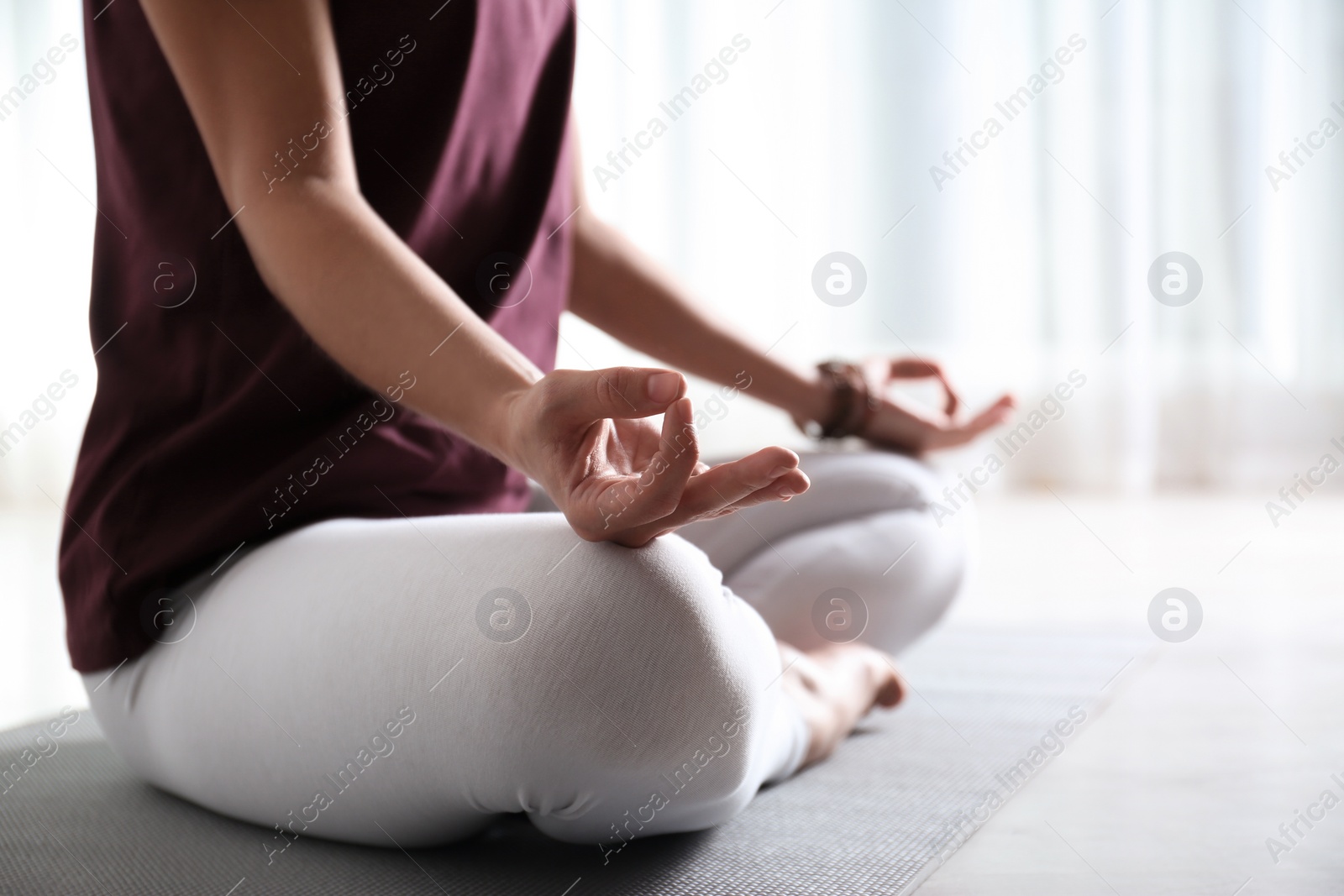 Photo of Woman practicing yoga on floor indoors, closeup. Space for text