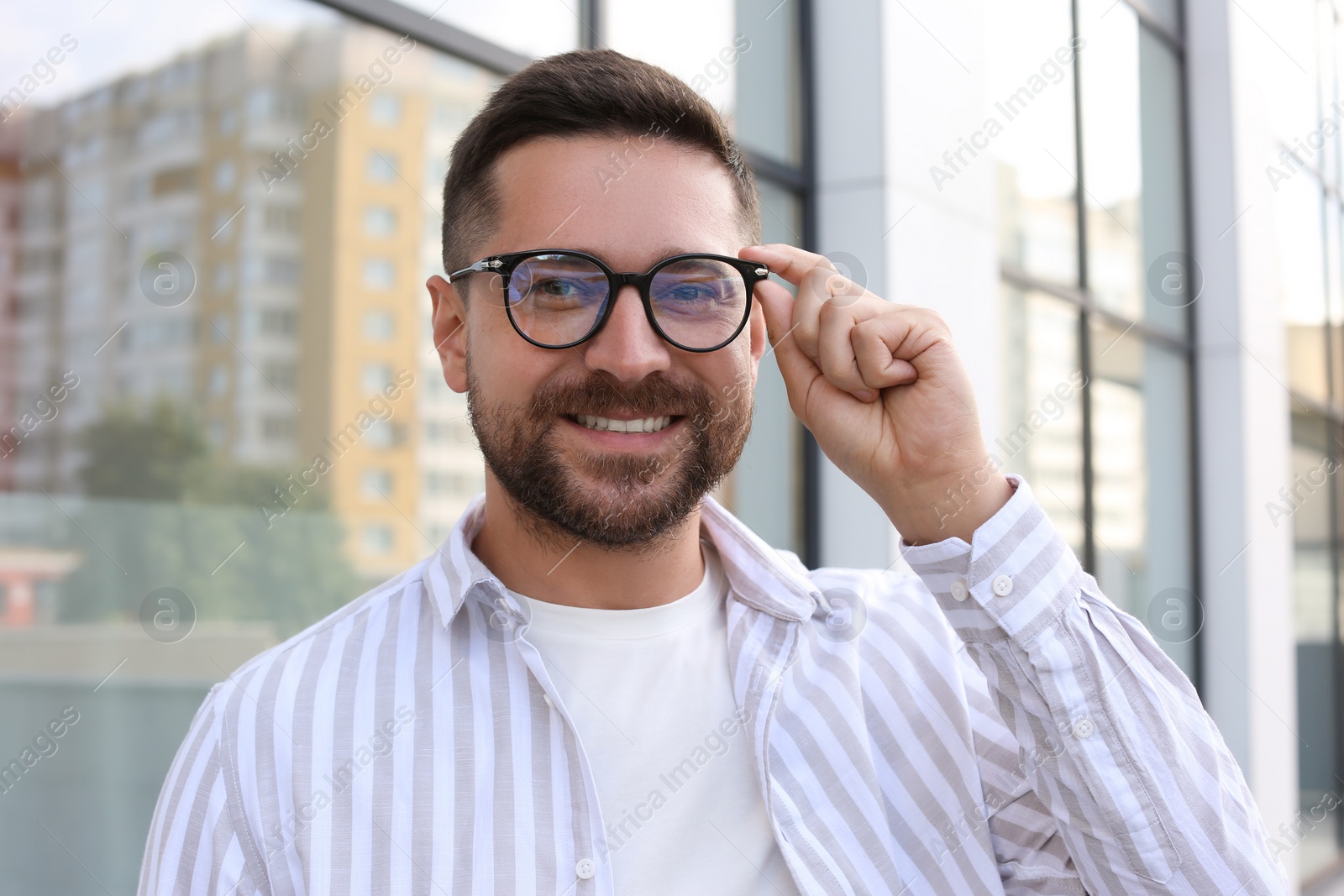 Photo of Portrait of handsome bearded man in glasses outdoors