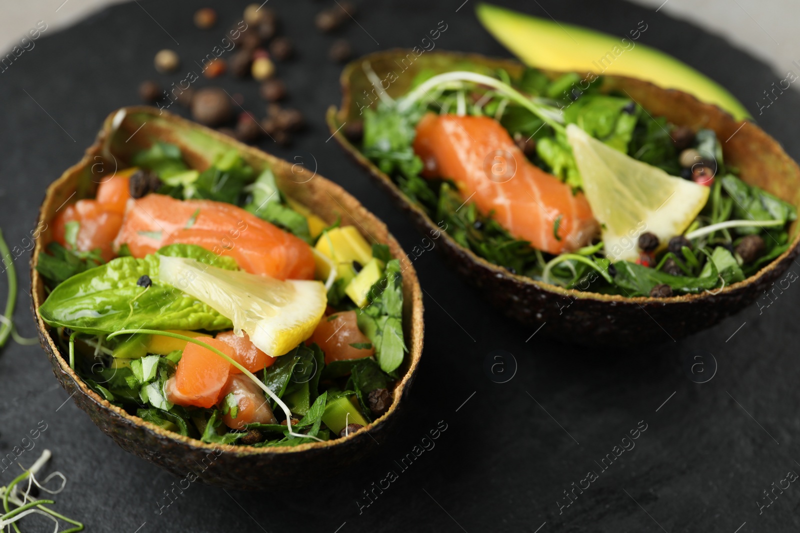 Photo of Delicious salmon with spinach served on slate board, closeup