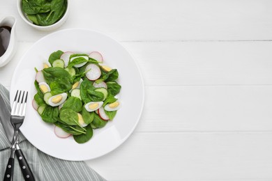 Photo of Delicious salad with boiled eggs, radish and spinach served on white wooden table, flat lay