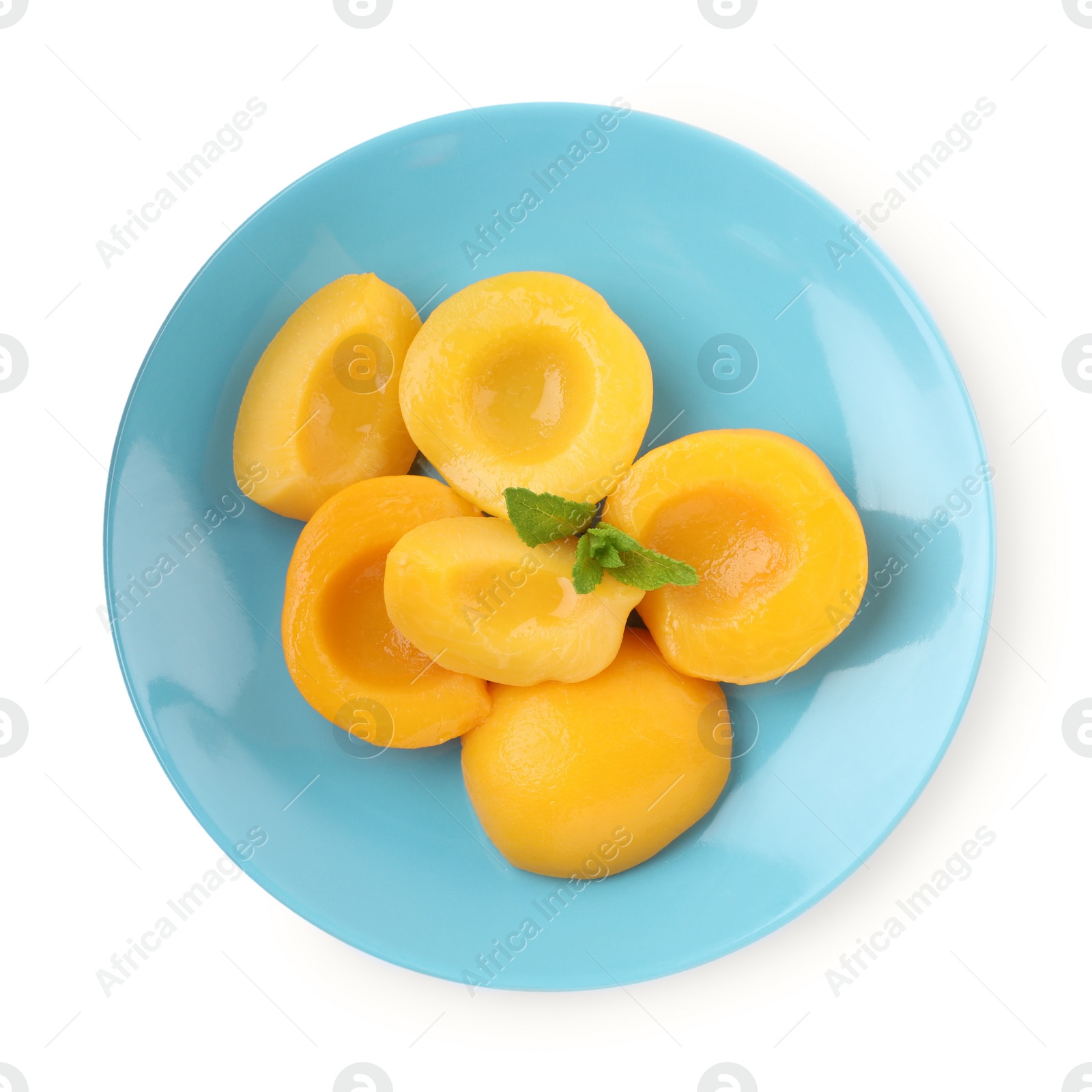 Photo of Halves of canned peaches with mint leaves isolated on white, top view