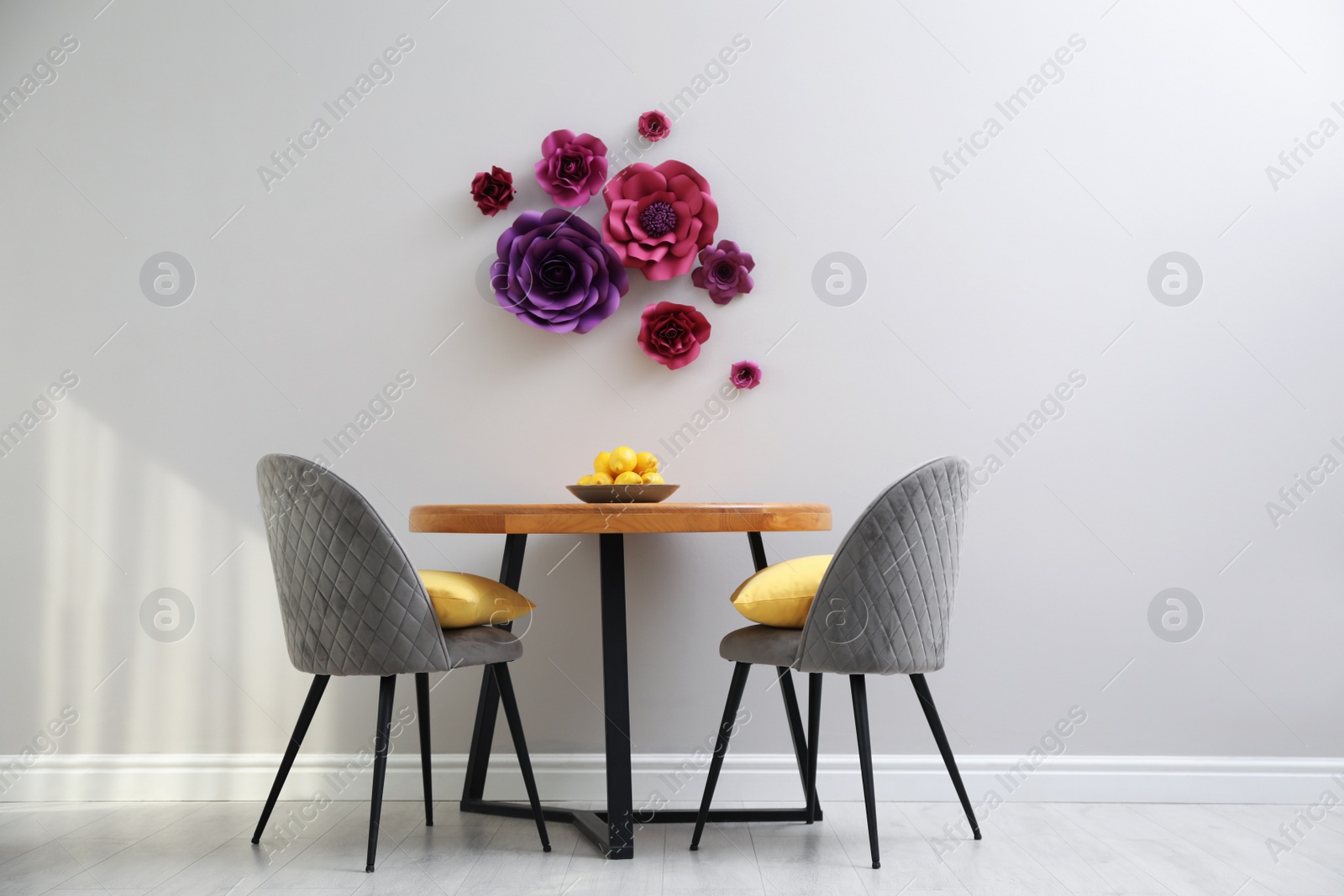 Photo of Dining table and chairs near wall with floral decor