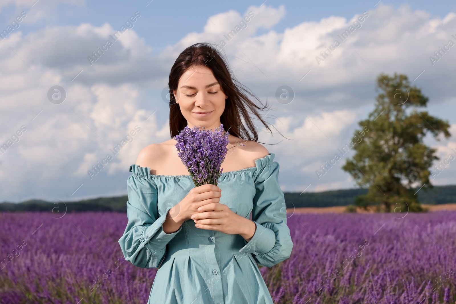 Photo of Beautiful woman with bouquet in lavender field