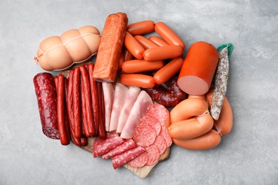 Photo of Different types of sausages on light grey table, flat lay