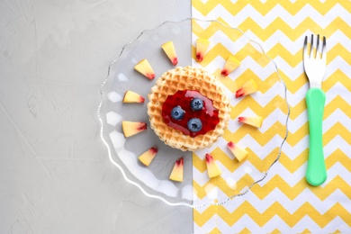 Photo of Tasty waffles served on grey table, flat lay. Creative idea for kids breakfast