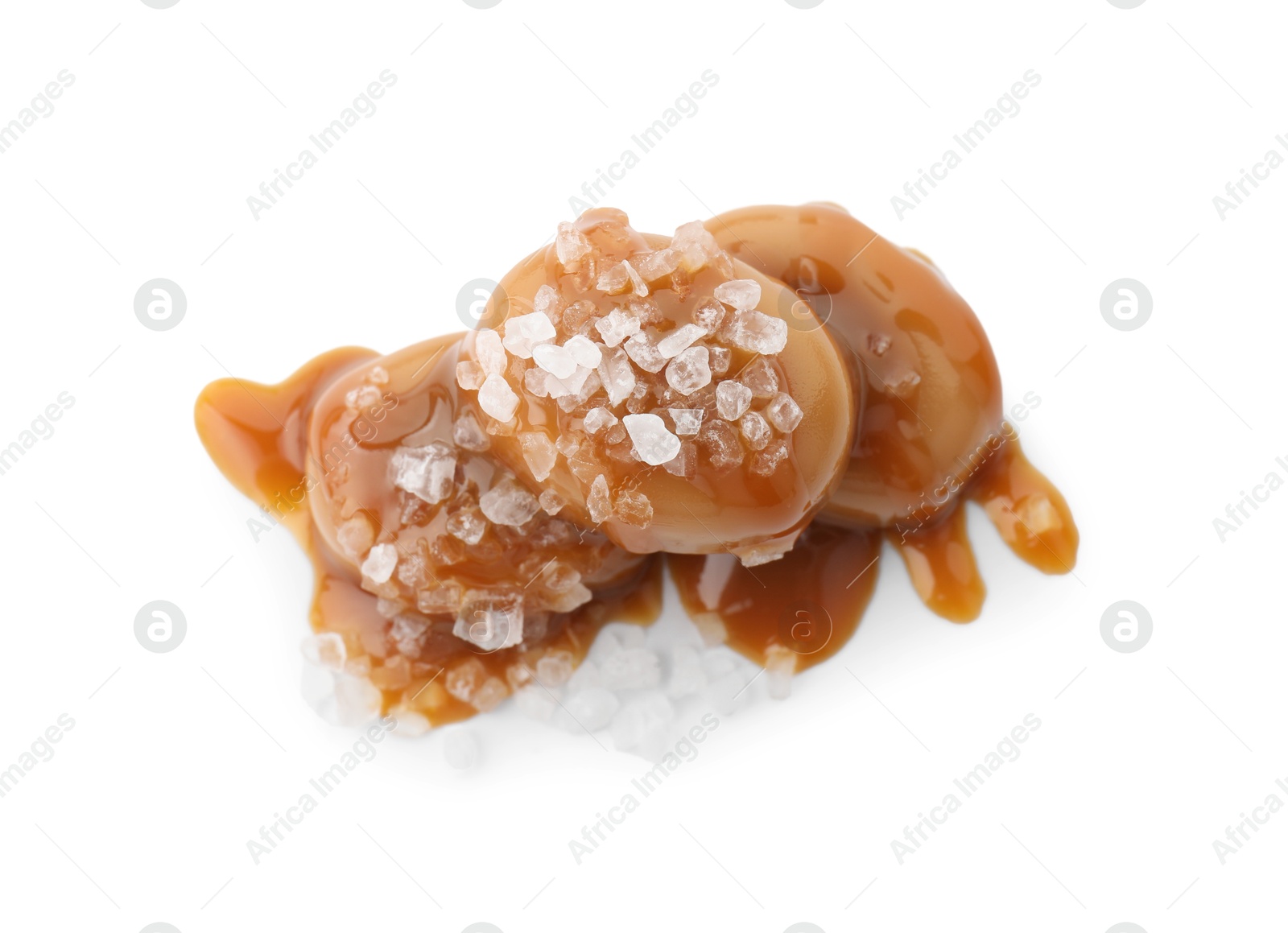 Photo of Yummy candies with caramel sauce and sea salt isolated on white, top view