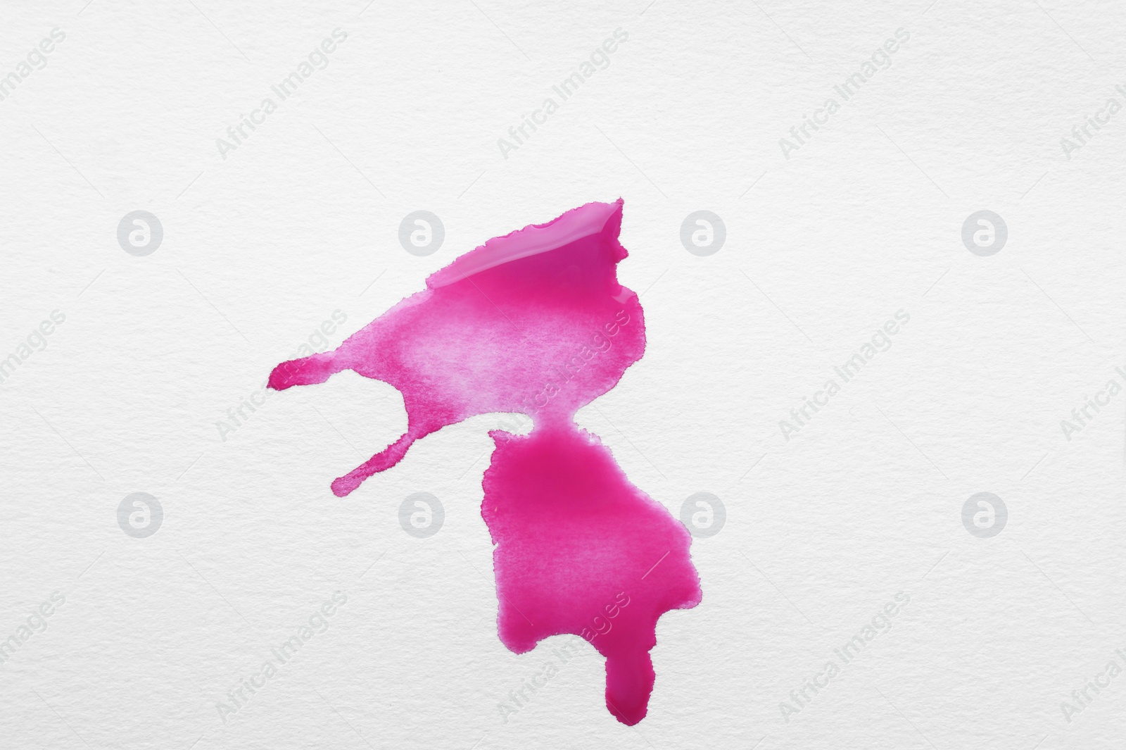 Photo of Blot of pink ink on white background, top view