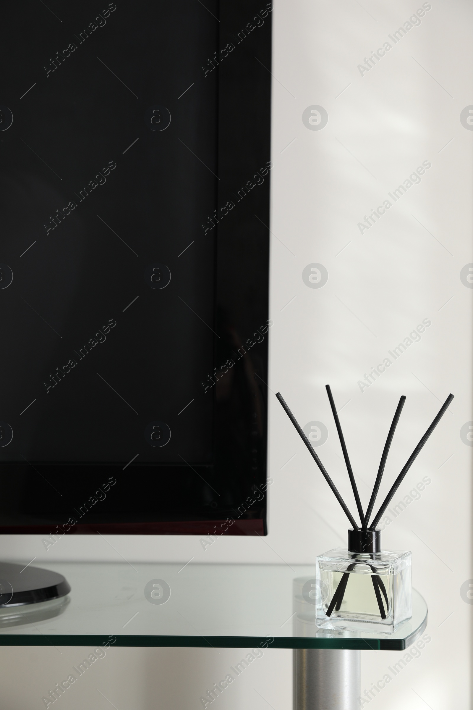 Photo of Aromatic reed air freshener on tv table indoors