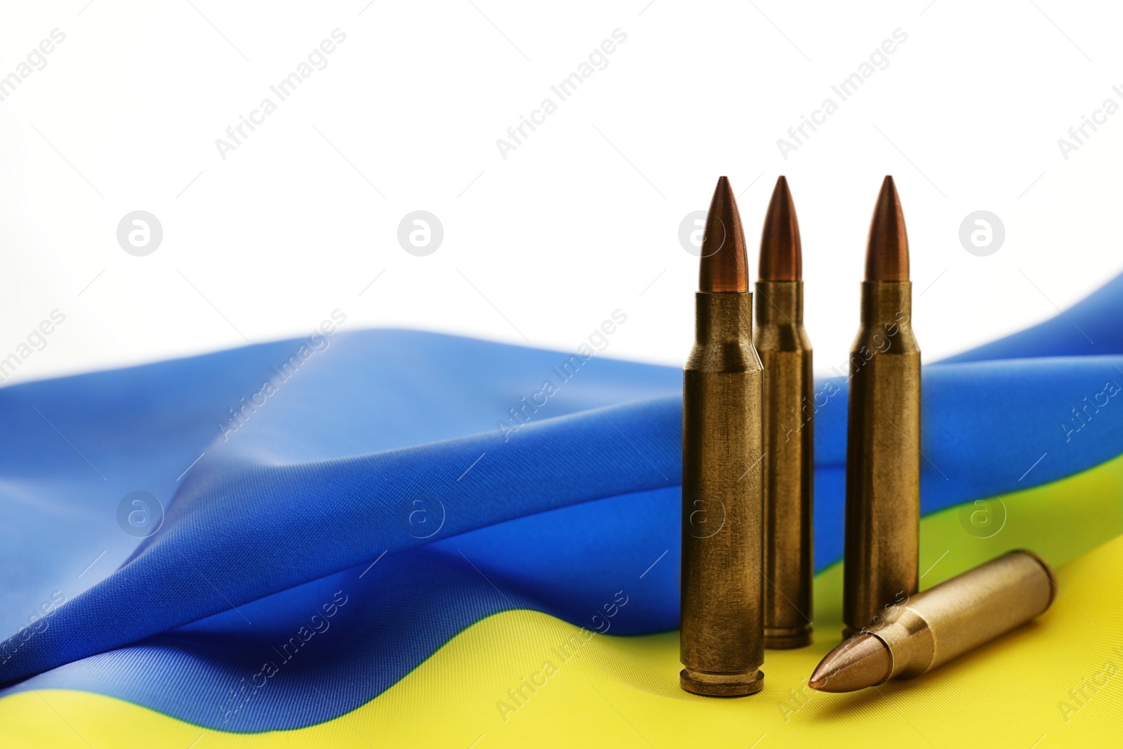 Photo of Bullets and national flag of Ukraine on white background