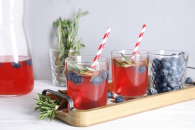 Tasty refreshing blueberry cocktail with rosemary on table