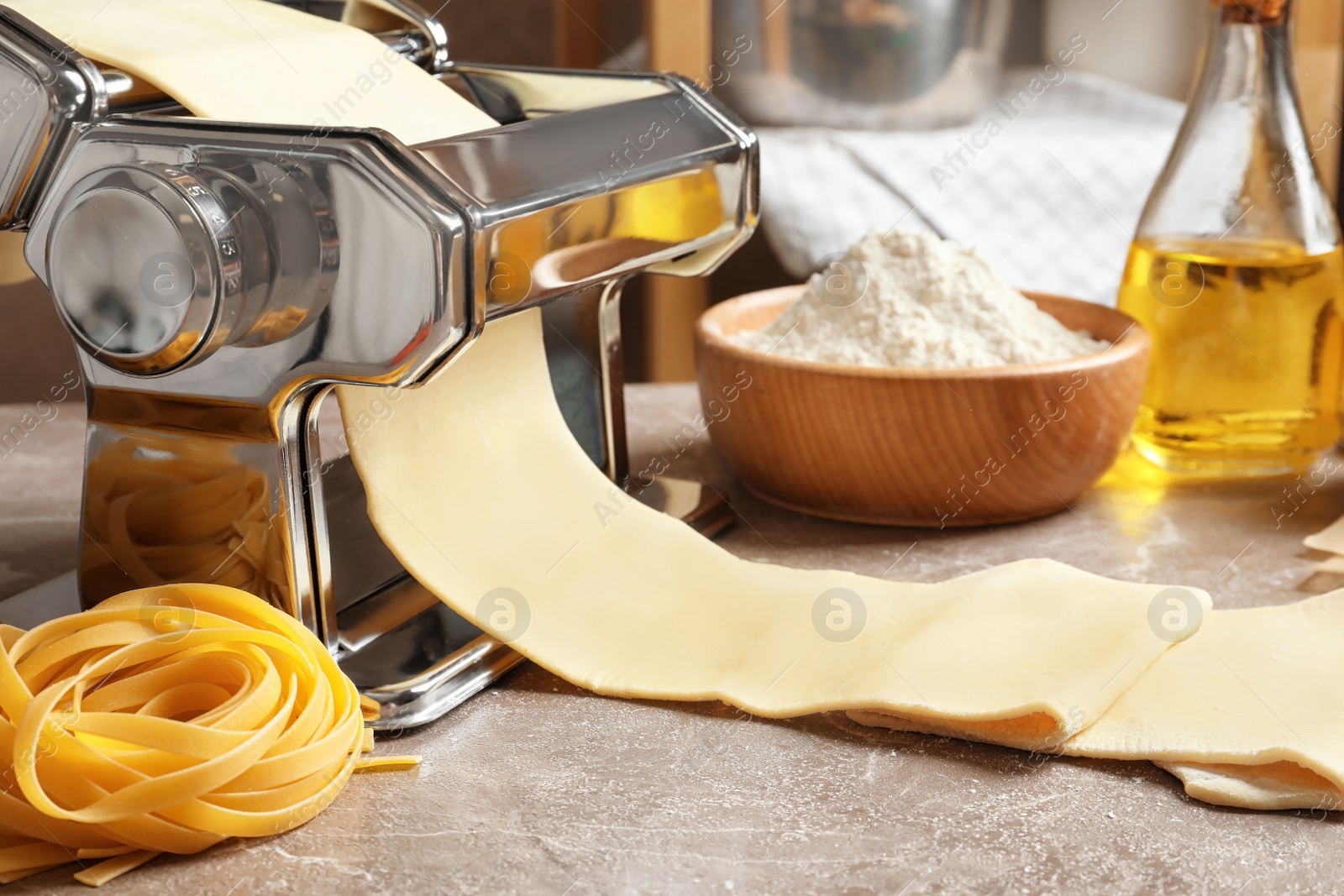 Photo of Pasta maker with dough on kitchen table