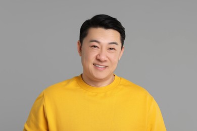 Portrait of happy man on grey background