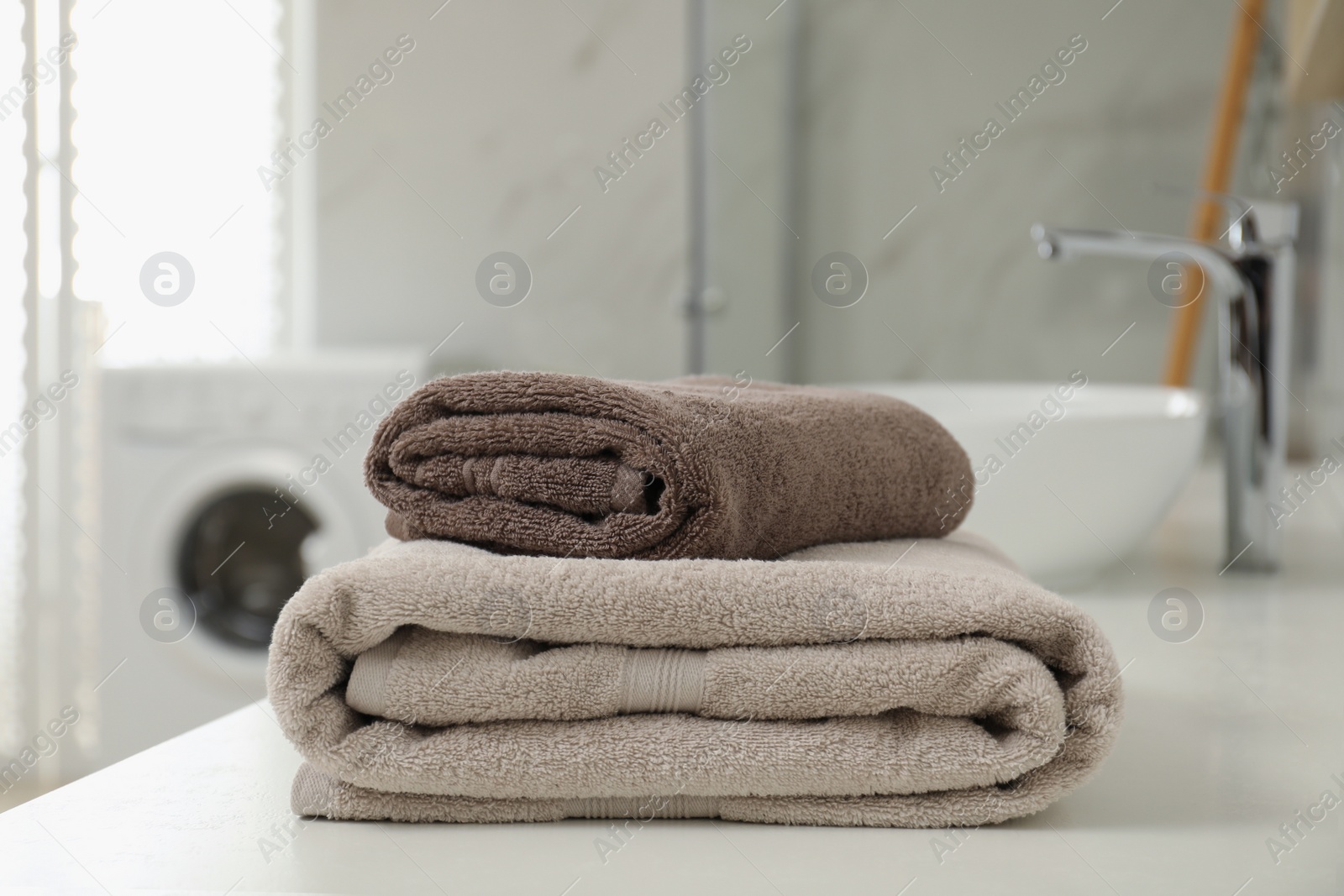 Photo of Stack of clean towels on bathroom countertop