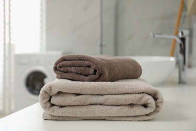 Photo of Stack of clean towels on bathroom countertop