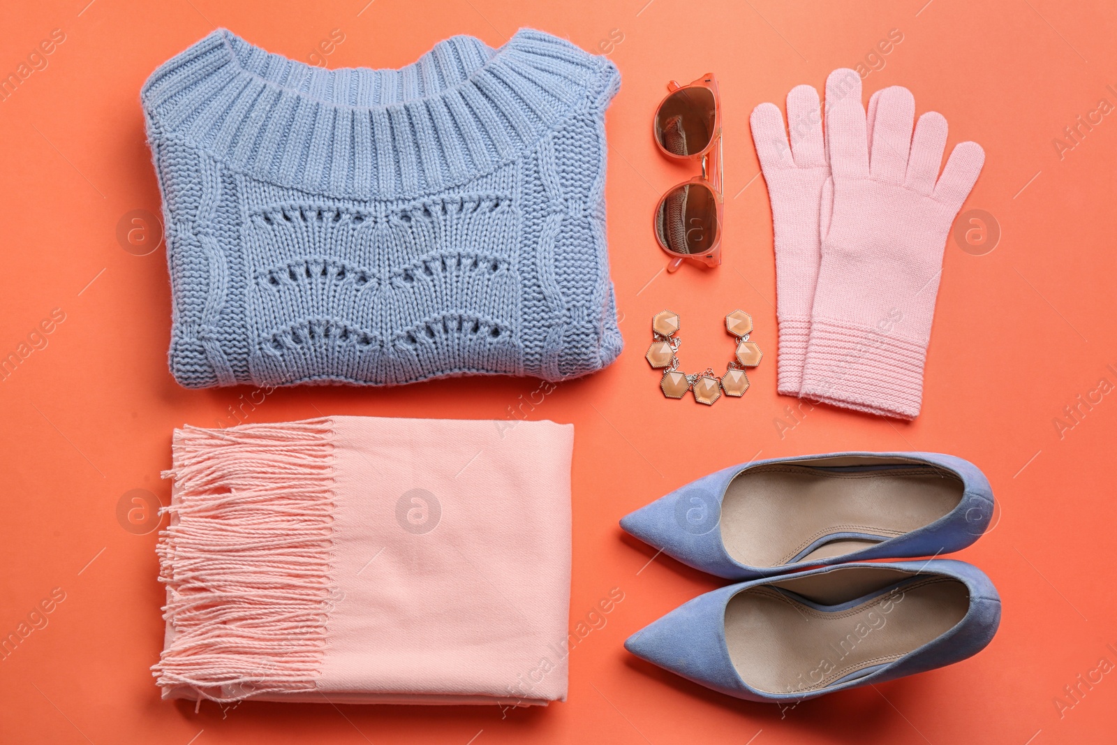 Photo of Flat lay composition with warm clothes on coral background