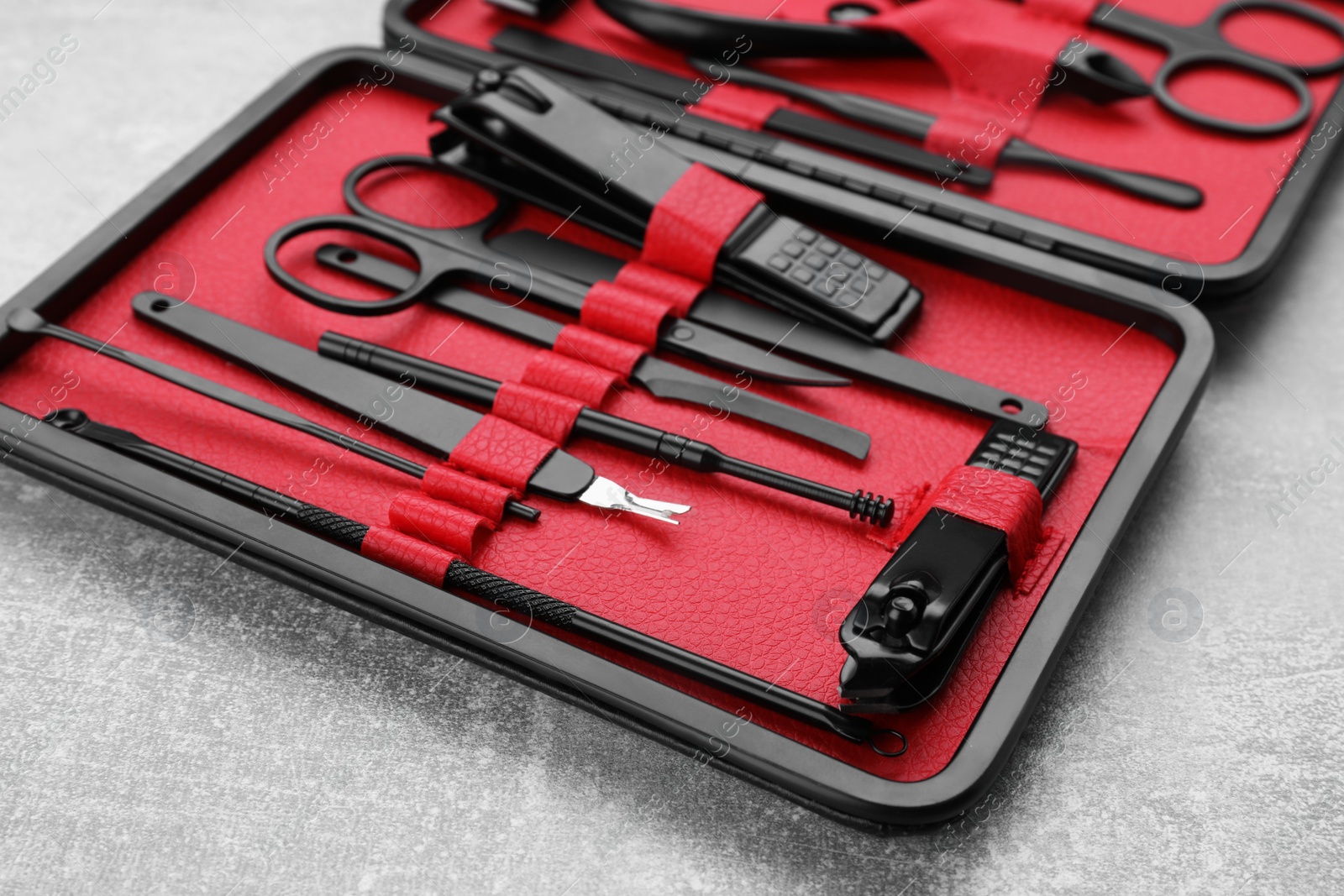 Photo of Kit of pedicure tools on light gray table, closeup