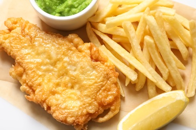 Photo of British Traditional Fish and potato chips on table, closeup