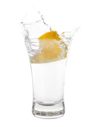 Photo of Vodka splashing out of shot glass with lemon on white background