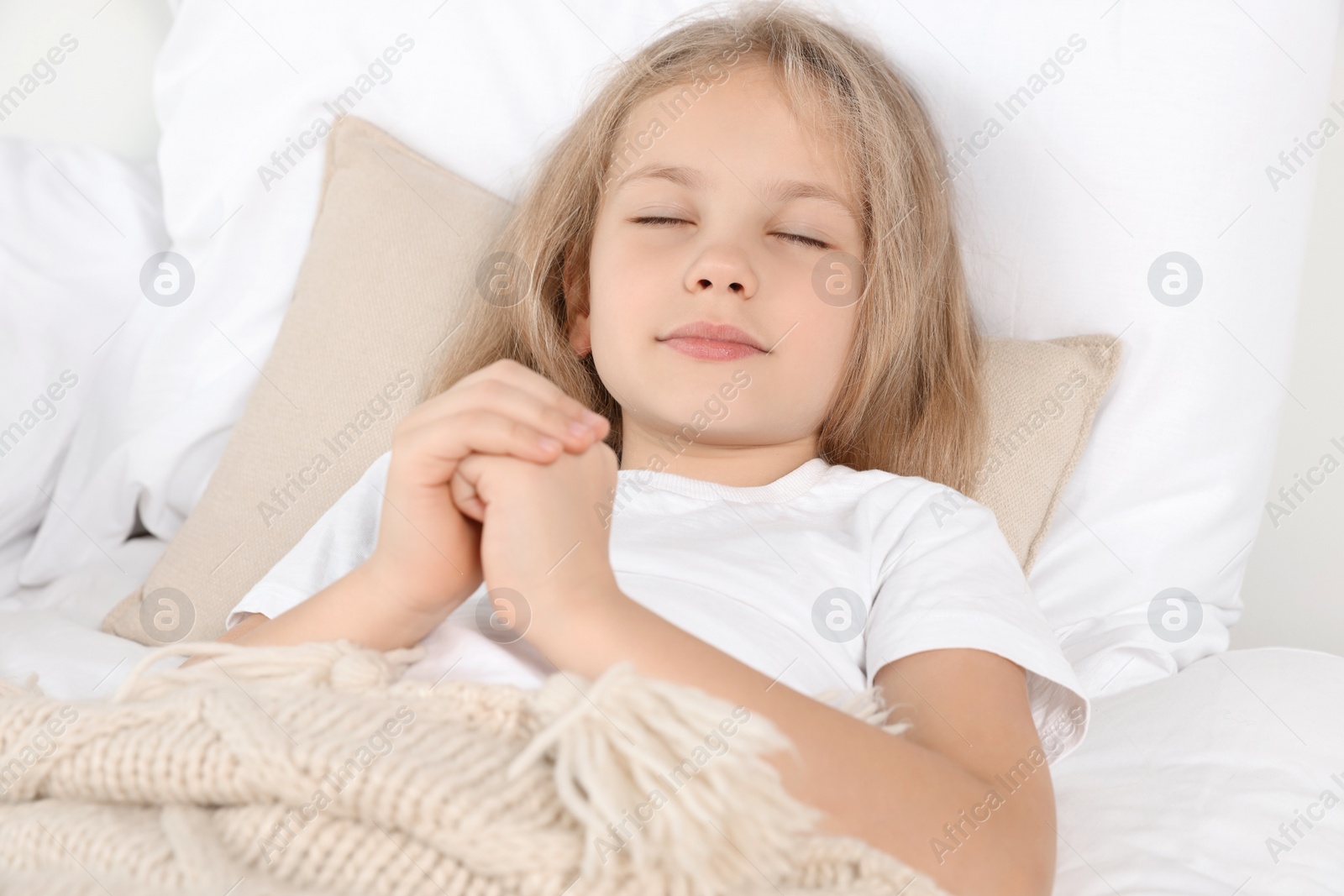 Photo of Girl with clasped hands praying in bed